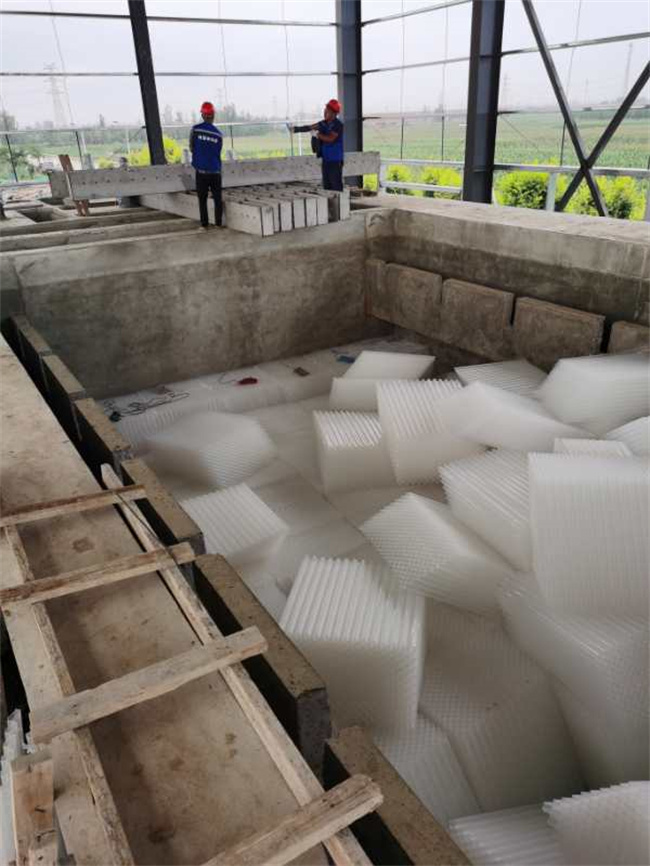 Inclined tube settler media modules being installed in a concrete treatment tank